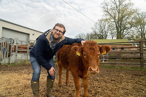 Henley & Thame MP Freddie van Mierlo standing next to a brown calf