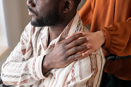 Person touching another's shoulder in sign of affection