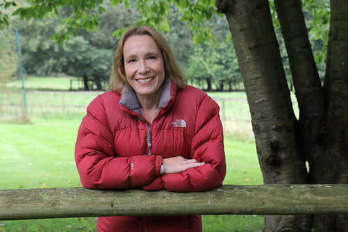 Helen leaning on a fence in rural North Shropshire